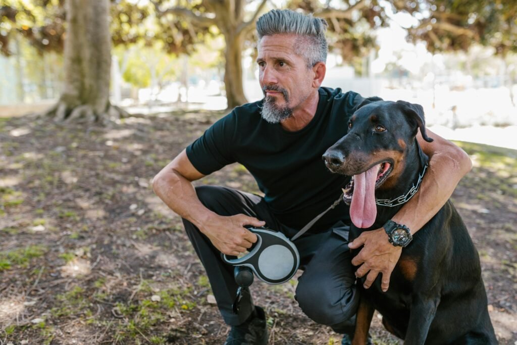 A person giving a treat to a dog who is sitting, using positive reinforcement during a dog training session.