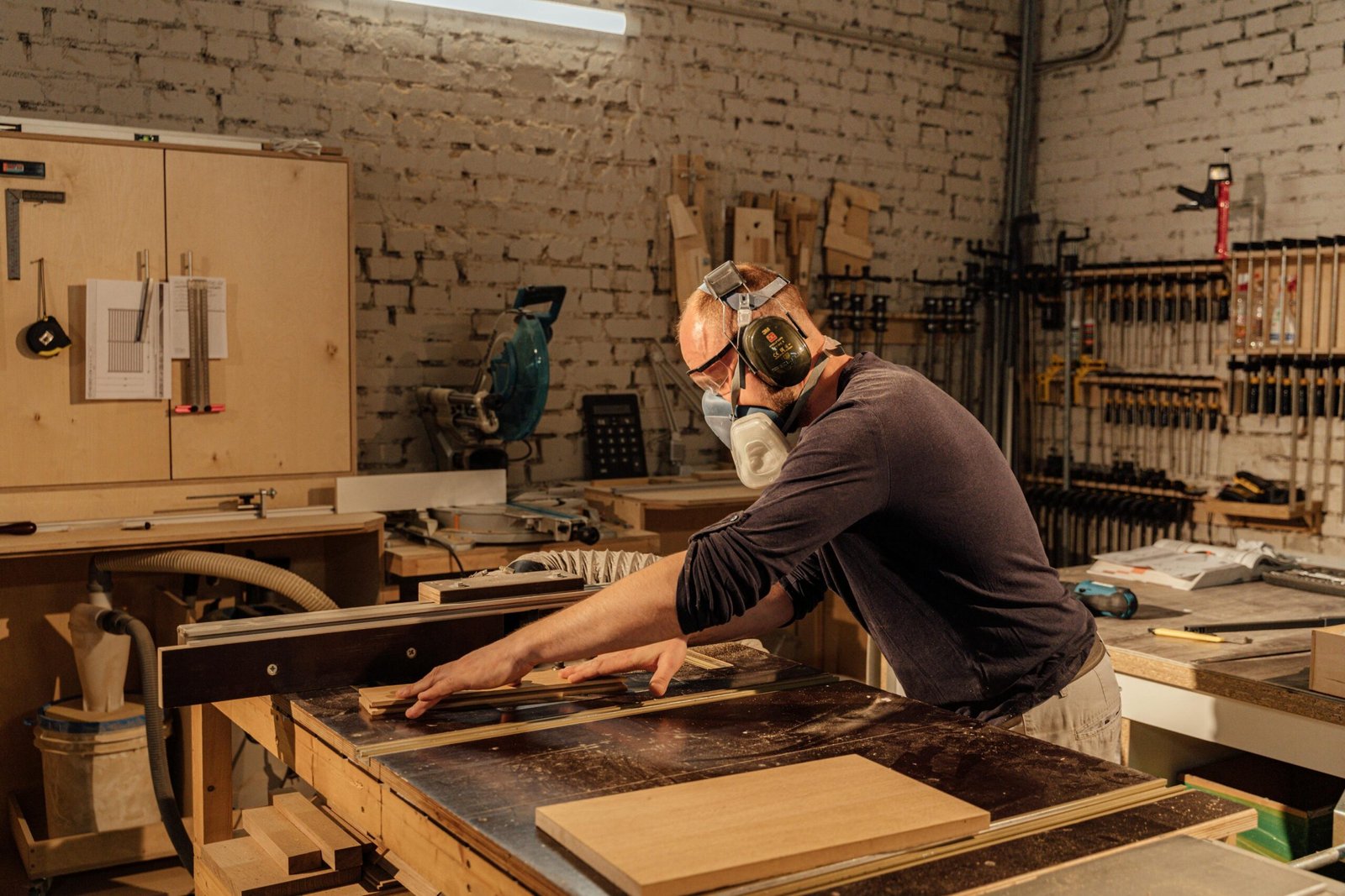 Person using a hand saw and square to cut a board, demonstrating basic tools used for simple woodworking projects for beginners
